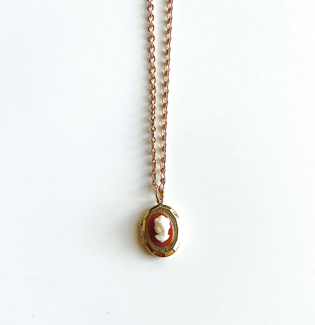 Orange and white cameo locket necklace on white background