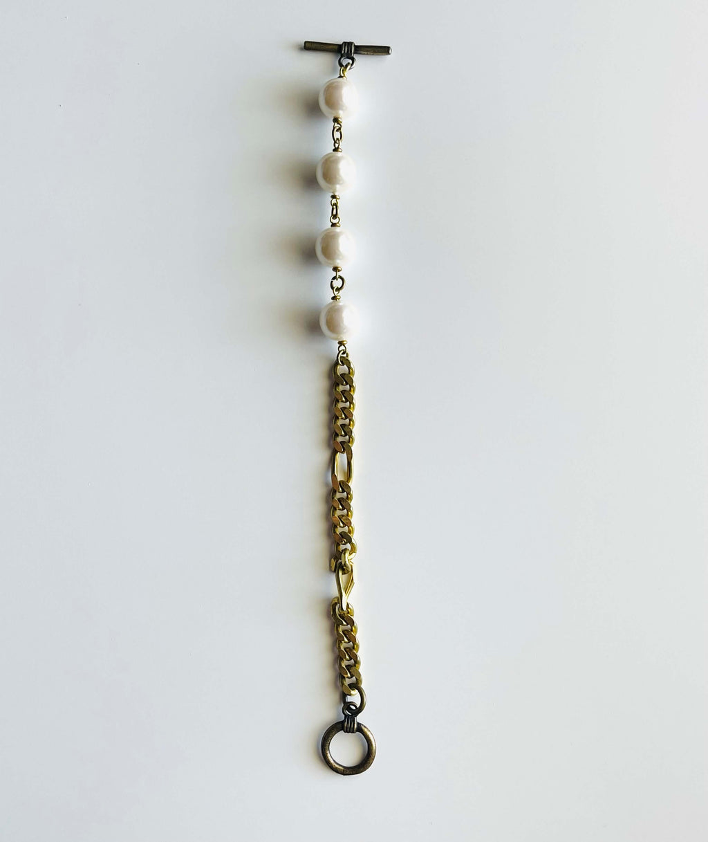 Yellow brass and white pearl bracelet on white background 
