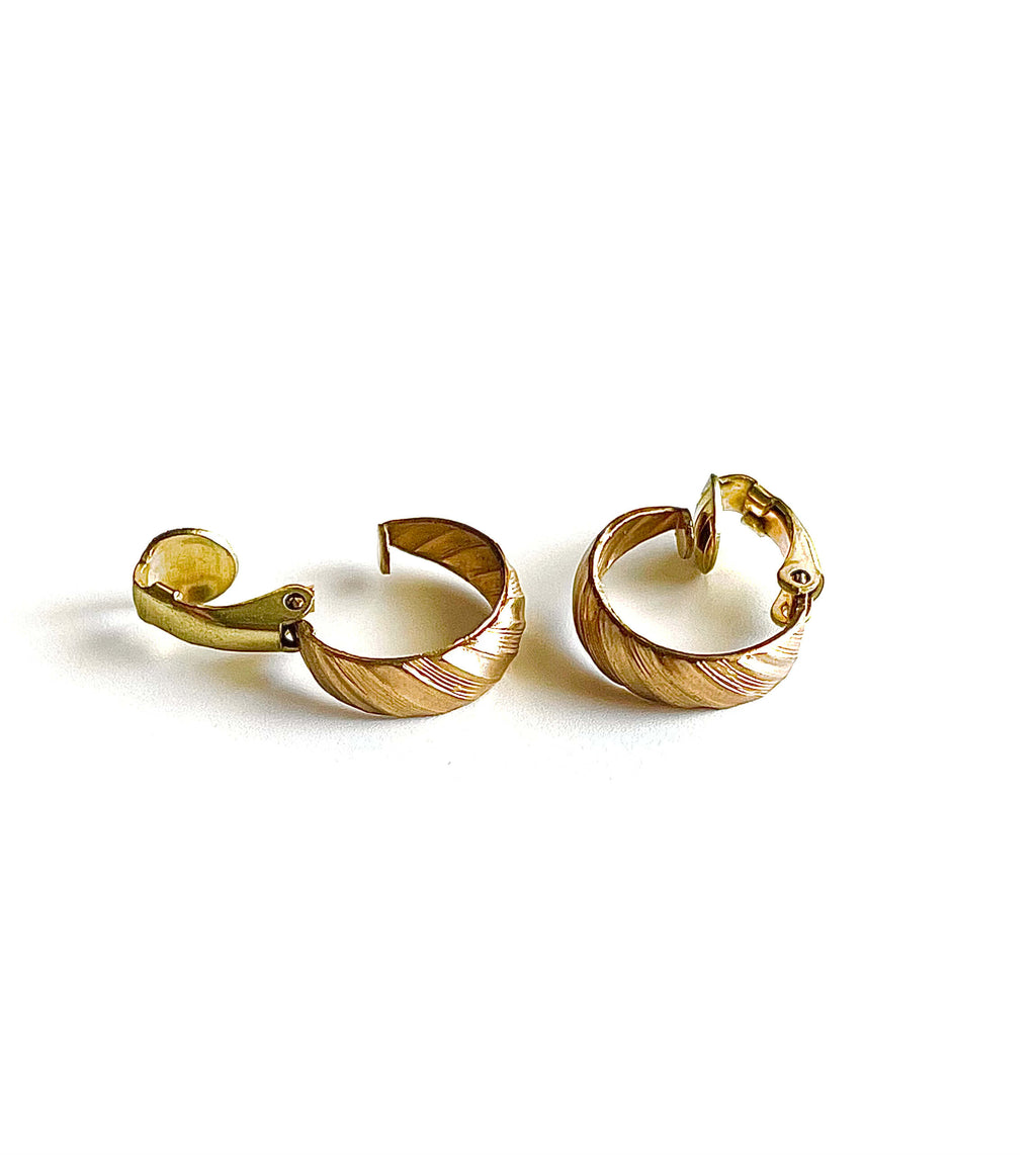 Yellow brass clip on small hoop earrings on a maroon background